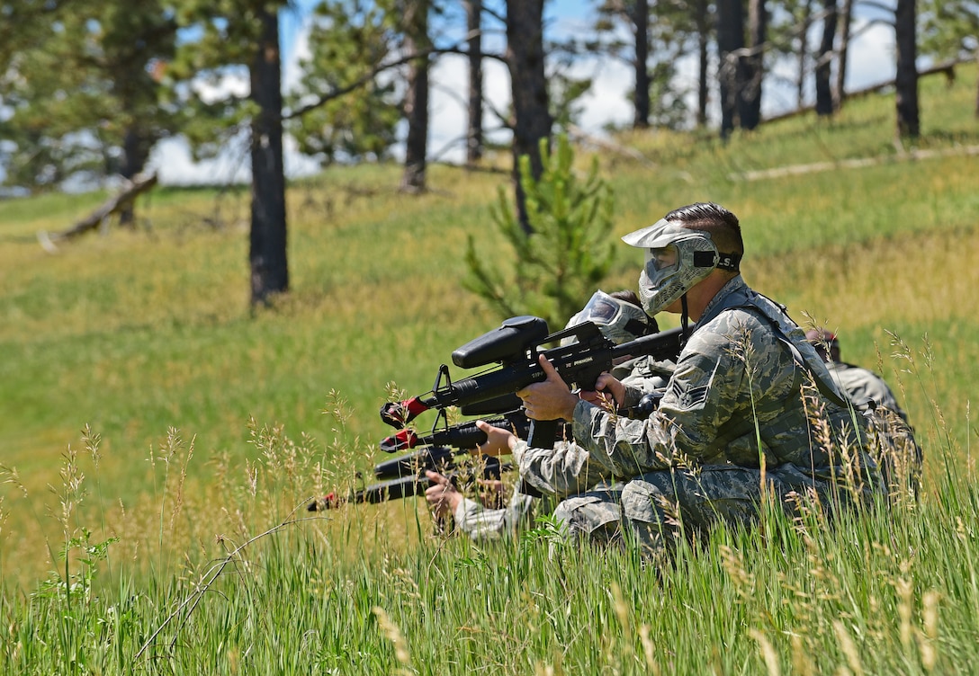 Airmen assigned to the 28th Civil Engineer Squadron, survey the area for threats at a training site in West Camp, S.D., June 19, 2017. They participated in a land navigation exercise as part of annual exercise Golden Coyote. (U.S. Air Force photo by Senior Airman James L. Miller)