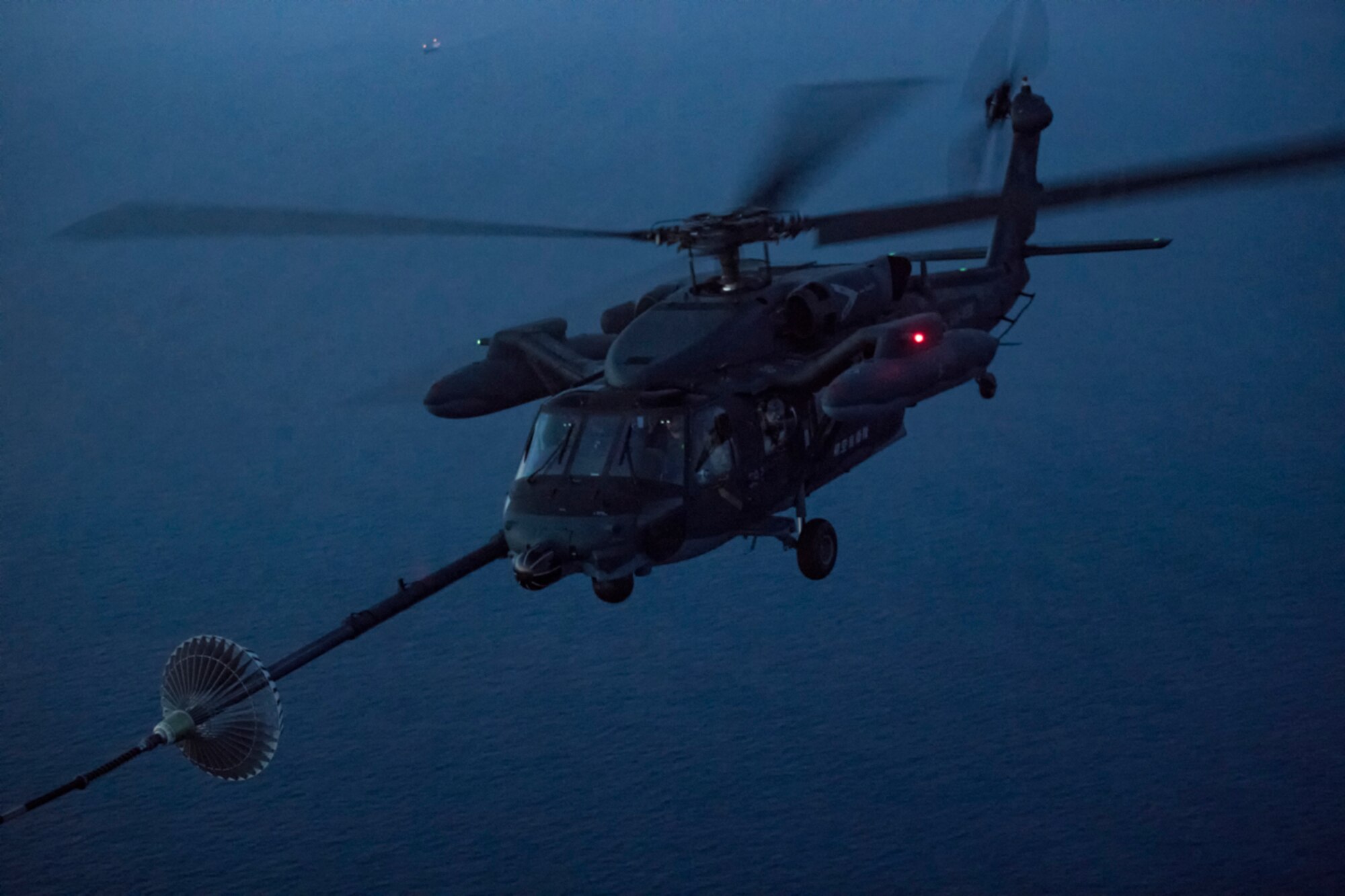 A Japan Air Self-Defense Force UH-60J Black Hawk assigned to the Hamamatsu Air Rescue Squadron executes helicopter air-to-air refueling over the Pacific Ocean, June 15, 2017, during Exercise Teak Jet. This is the first time that members of the 353rd Special Operations Group held HAAR training at night with JASDF members in Honshu Island in Japan. (U.S. Air Force photo by Yasuo Osakabe)