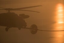 A Japan Air Self-Defense Force UH-60J Black Hawk helicopter assigned to the Komatsu Air Rescue Squadron executes a helicopter air-to-air refueling over the Sea of Japan, June 19, 2017, during Exercise Teak Jet. This is the first time that members of the 353rd Special Operations Group held HAAR training at night with JASDF members in Honshu Island in Japan. Exercise Teak Jet is a joint combined exchange training (JCET) focused on improving interoperability between U.S. Air Force and Japan Air Self-Defense Force. (U.S. Air Force photo by Yasuo Osakabe)