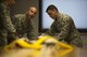 U.S. Air Force Master Sergeant John Comeens, left, 52nd Operations Support Squadron first sergeant, learns how to pack a pilot parachute during the commander’s parachute shop familiarization tour at Spangdahlem Air Base, Germany, June 23, 2017. The tour gave the new squadron commander and first sergeant a chance to see the aircrew flight equipment section and experience multiple mock parachute packs. (U.S. Air Force photo by Senior Airman Preston Cherry)