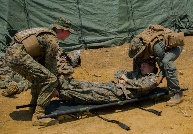 U.S. Navy Petty Officer 3rd Class Garrett Agel, left, a corpsman with Marine Wing Support Squadron (MWSS) 171, based out of Marine Corps Air Station Iwakuni, and U.S. Marine Corps Sgt. Barry Bethea, right, an Aircraft Rescue and Firefighting Specialist with MWSS-171, lift a simulated casualty off a stretcher during a mass casualty drill while participating in exercise Eagle Wrath 2017 at Combined Arms Training Center Camp Fuji, Japan, June 15, 2017. The purpose of the drill was to see how medical personnel react in coalition with the Marines to make sure they are working in a fluid manner. Eagle Wrath 2017 is a two-week training evolution focusing on air base ground defense and establishing a forward operating base in an austere environment. (U.S. Marine Corps photo by Lance Cpl. Stephen Campbell)