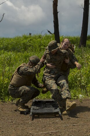 U.S. Navy Petty Officer 3rd Class Rebecca Hurst, a corpsman with Marine Wing Support Squadron (MWSS) 171, based out of Marine Corps Air Station Iwakuni, lifts a simulated casualty onto a stretcher during an unexpected mass casualty drill while participating in exercise Eagle Wrath 2017 at Combined Arms Training Center Camp Fuji, Japan, June 15, 2017. The purpose of the drill was to see how medical personnel react in coalition with the Marines to make sure they are working in a fluid manner. Eagle Wrath 2017 is a two-week training evolution focusing on air base ground defense and establishing a forward operating base in an austere environment. (U.S. Marine Corps photo by Lance Cpl. Stephen Campbell)