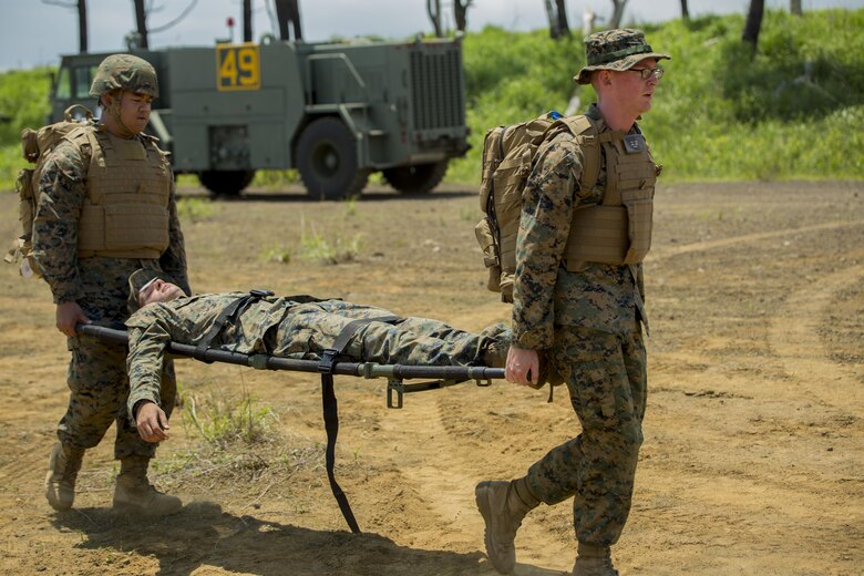 U.S. Navy Petty Officer 3rd Class Michael Delacruz, left, and Petty Officer 3rd Class Garrett Agel, corpsmen with Marine Wing Support Squadron (MWSS) 171, based out of Marine Corps Air Station Iwakuni, transport a casualty during an unexpected mass casualty drill while participating in exercise Eagle Wrath 2017 at Combined Arms Training Center Camp Fuji, Japan, June 15, 2017. The purpose of the drill was to see how medical personnel react in coalition with the Marines to make sure they are working in a fluid manner. Eagle Wrath 2017 is a two-week training evolution focusing on air base ground defense and establishing a forward operating base in an austere environment. (U.S. Marine Corps photo by Lance Cpl. Stephen Campbell)
