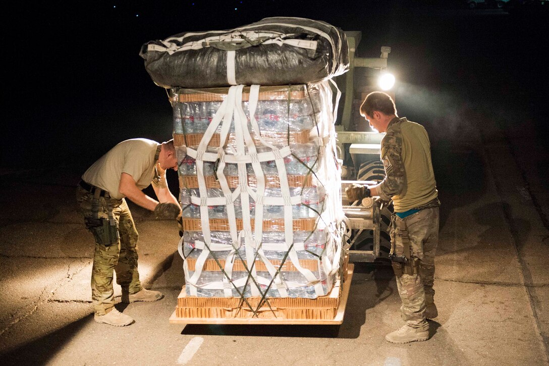Air Force MC-130 aircraft crew chiefs secure a pallet of supplies on a forklift before loading it onto a MC-130 Hercules aircraft for an airdrop over Syria, June 22, 2017. Air Force photo by Master Sgt. Jason Robertson