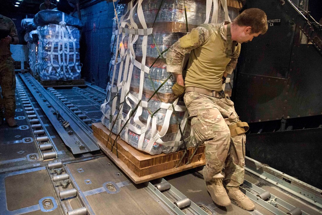 Air Force crew chiefs load a pallet of supplies onto an MC-130 Hercules aircraft in preparation for an airdrop over Syria, June 22, 2017. Air Force photo by Master Sgt. Jason Robertson