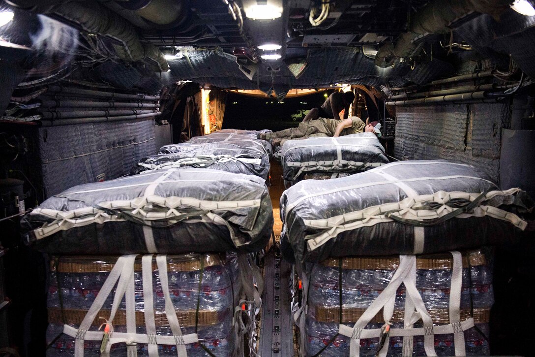 Air Force crew chiefs aboard an MC-130 Hercules aircraft secure pallets of supplies and cargo intended for an airdrop over Syria, June 22, 2017. Air Force photo by Master Sgt. Jason Robertson