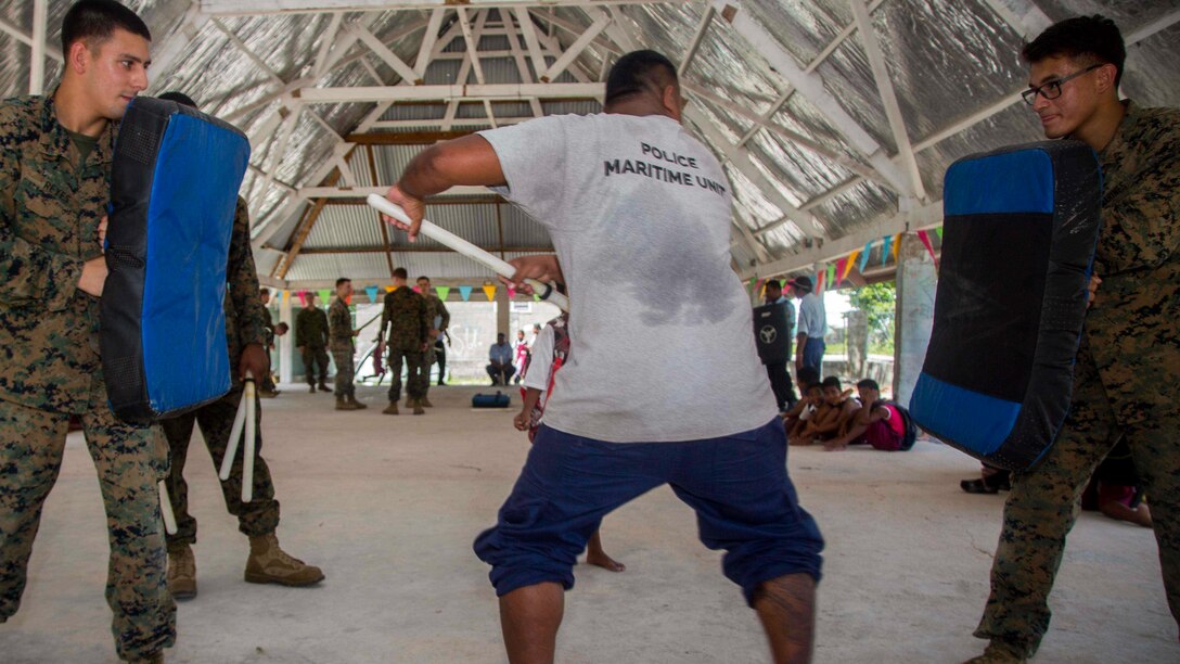 U.S. Marines with Task Force Koa Moana 17 hold striking pads for a member of the Kiribati National Police Maritime Unit while conducting striking drills on Betio Island, Tarawa Atoll, Kiribati, June 13, 2017. Koa Moana 17 is designed to improve theater security, law enforcement, and infantry training in the Pacific region in order to enhance interoperability with partner nations. (U.S. Marine Corps photo by MCIPAC Combat Camera Lance Cpl. Juan C. Bustos)