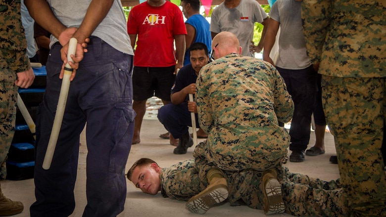 U.S. Marines with Task Force Koa Moana 17 show Kiribati residents hostile detainee handling techniques on Betio Island, Tarawa Atoll, Kiribati, June 13, 2017.  Koa Moana 17 is designed to improve theater security, law enforcement, and infantry training in the Pacific region in order to enhance interoperability with partner nations. (U.S. Marine Corps photo by MCIPAC Combat Camera Lance Cpl. Juan C. Bustos)