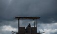 A U.S. Army Reserve military police with the 325th MP Company, out of Fresno, California, pulls guard duty under a dark, angry sky during Guardian Justice at Fort McCoy, Wisconsin, June 24. Guardian Justice is a functional exercise, broken down into two-week cycles, centered on squad and team-level training with a focus on internment, resettlement, detainee operations and combat support. During each two-week cycle, Soldiers train on internment operations, weapons qualification, biometrics, reflexive fire, Military Operations on Urbanized Terrain (MOUT), non-lethal Tasers, MP battle drills and include a situational training exercise. (U.S. Army Reserve photo by Sgt. Audrey Hayes)