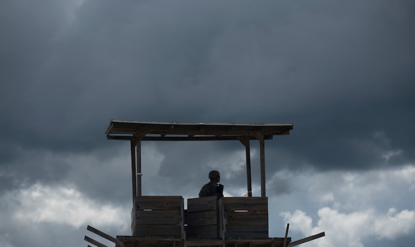 A U.S. Army Reserve military police with the 325th MP Company, out of Fresno, California, pulls guard duty under a dark, angry sky during Guardian Justice at Fort McCoy, Wisconsin, June 24. Guardian Justice is a functional exercise, broken down into two-week cycles, centered on squad and team-level training with a focus on internment, resettlement, detainee operations and combat support. During each two-week cycle, Soldiers train on internment operations, weapons qualification, biometrics, reflexive fire, Military Operations on Urbanized Terrain (MOUT), non-lethal Tasers, MP battle drills and include a situational training exercise. (U.S. Army Reserve photo by Sgt. Audrey Hayes)