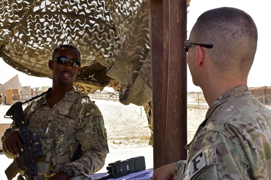 Senior Airman Sionte Campbell, 443d Expeditionary Security Forces Squadron entry controller, speaks to Capt. Jeffrey Robertson, 407th ESFS operations offficer June 22, 2017, at Al Asad Airbase, Iraq. Robertson visited security forces members at Al Asad to check on his Airmen forward deployed there and the current status and capabilities of the unit to accomplish the mission. (U.S. Air Force photo by Senior Airman Ramon A. Adelan)