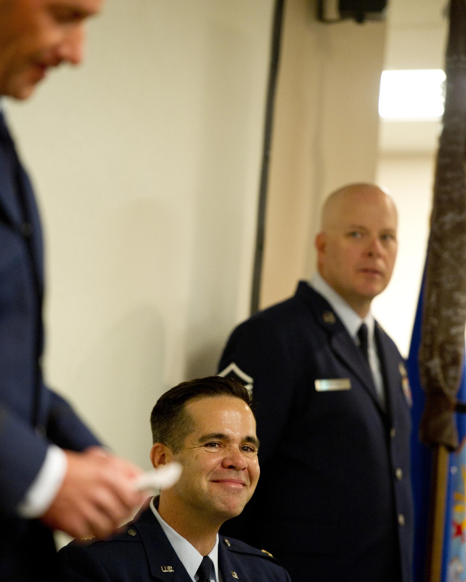 U.S. Air Force Maj. Hamilton Underwood smiles from a joke told by Lt. Col. John Robinson, commander of the 315th Operations Group, during Lt. Col's opening remarks before Maj. Underwood assumes command of the newly activated 4th Combat Camera Squadron, as Master Sgt. Chris Fickling, holds the guidon, at Joint Base Charleston, South Carolina, May 5, 2017. The 4th CTCS was reactivated in South Carolina after being deactivated August 2015 in California. (U.S. Air Force photo by Tech. Sgt. Stephen D. Schester) 