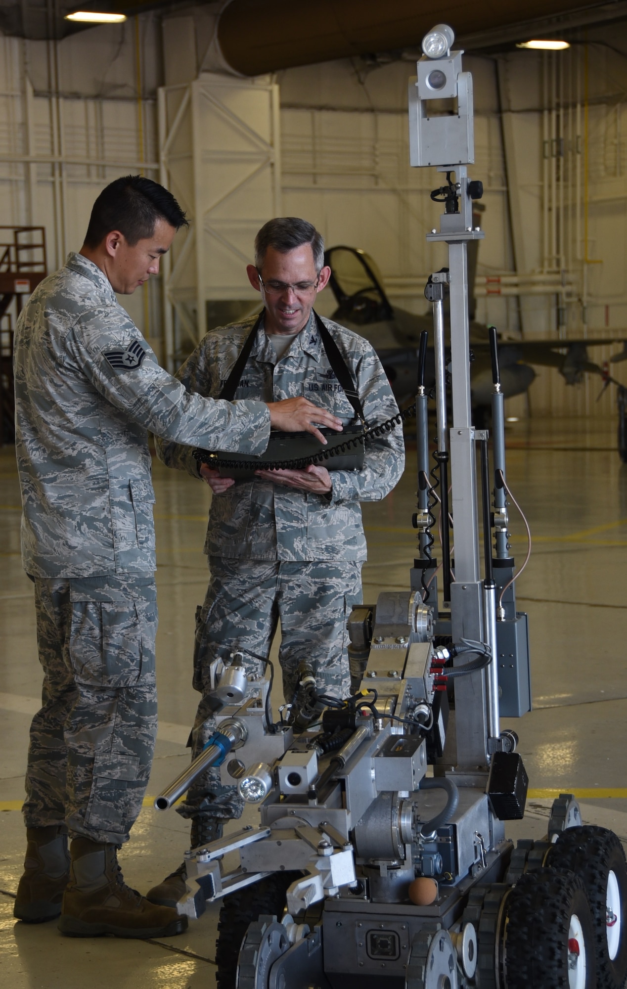 Staff Sgt. Benjamin Kim, a 301st Explosive Ordnance Disposal technician, explains the robot controls to Col. Damon Feltman, Tenth Air Force vice commander, while he operates the platform May 15, 2017 during a unit visit here. EOD uses the heavy-duty robot to dispose of munitions when they respond to local community requests and IED threats in 35 counties in Texas.