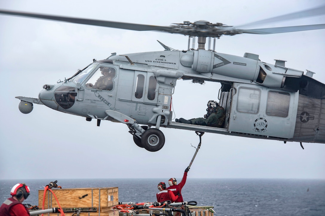 Aviation ordnance sailors connect a "pogo stick" to an MH-60S Sea Hawk helicopter during an ammunition offload aboard the aircraft carrier USS Dwight D. Eisenhower in the Atlantic Ocean, June 21, 2017. Navy photo by Petty Officer 3rd Class Nathan T. Beard