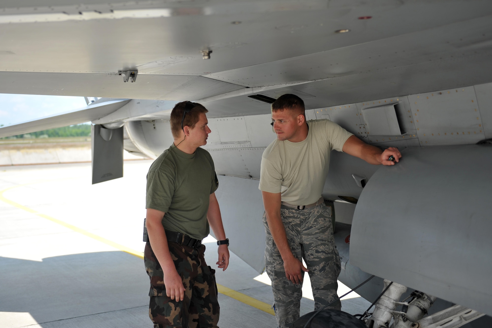 Airman First Class Damon St. John, an F-16 Fighting Falcon mechanic, teaches 1 Lt. Laszlo Molnar, a JAS 39 Grippen mechanical engineer assigned to the Hungarian Air Force, to launch an F-16 Fighting Falcon assigned to the 180th Fighter Wing, Ohio Air National Guard May 26, 2017 at Kecskemet Air Base in Hungary. The United States, along with Hungary, Slovakia, Croatia, Czech Republic and Slovenia, participated in Load Diffuser 17, a two-week Hungarian-led multinational exercise focused on enhancing interoperability capabilities and skills among NATO allied and European partner air forces by conducting joint operations and air defenses to maintain joint readiness, while also bolstering relationships within the U.S. Air National Guard’s State Partnership Program initiatives. Ohio became state partners with Hungary in 1993. Air National Guard photo by Senior Master Sgt. Beth Holliker.