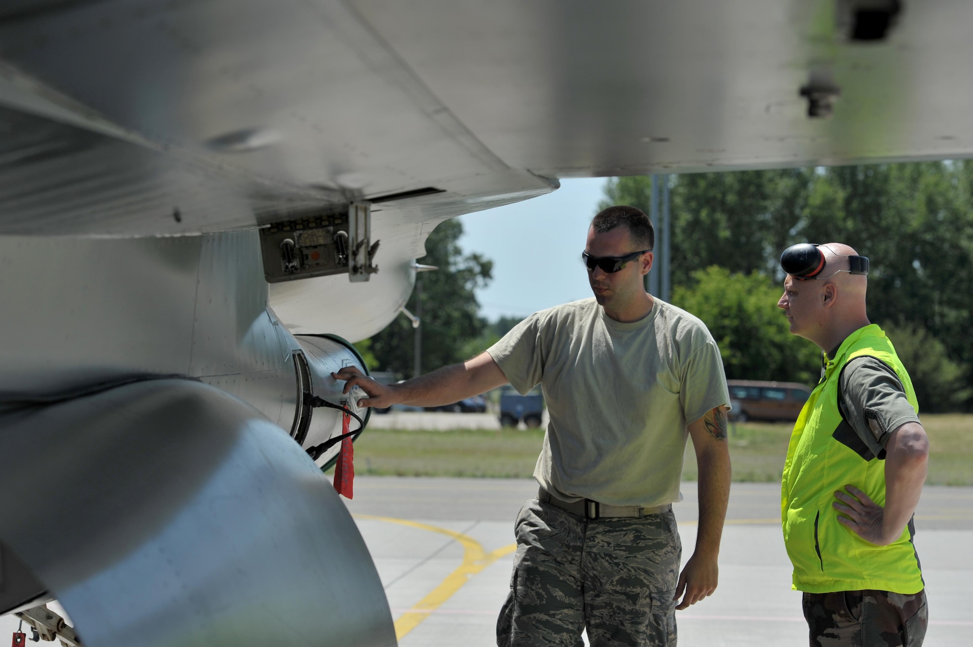 U.S. Air Force Senior Airman Brad Asbury, an F-16 Fighting Falcon mechanic assigned to the 180th Fighter Wing, Ohio Air National Guard, explains preflight inspection procedures to Hungarian Air Force Maj. Oszvald Juhasz, a logistical specialist assigned to the 59th Air Base, May 30, 2017, in Kecskemet, Hungary. More than 150 Airmen from the 180FW and eight F-16s are participating in the Hungarian led, two week multinational exercise focused on enhancing interoperability capabilities and skills among NATO allied and European partner air forces by conducting joint operations and air defenses to maintain joint readiness, while also bolstering relationships within the U.S. Air National Guard’s State Partnership Program initiatives. Ohio became state partners with Hungary in 1993. Air National Guard photo by Senior Master Sgt. Beth Holliker.