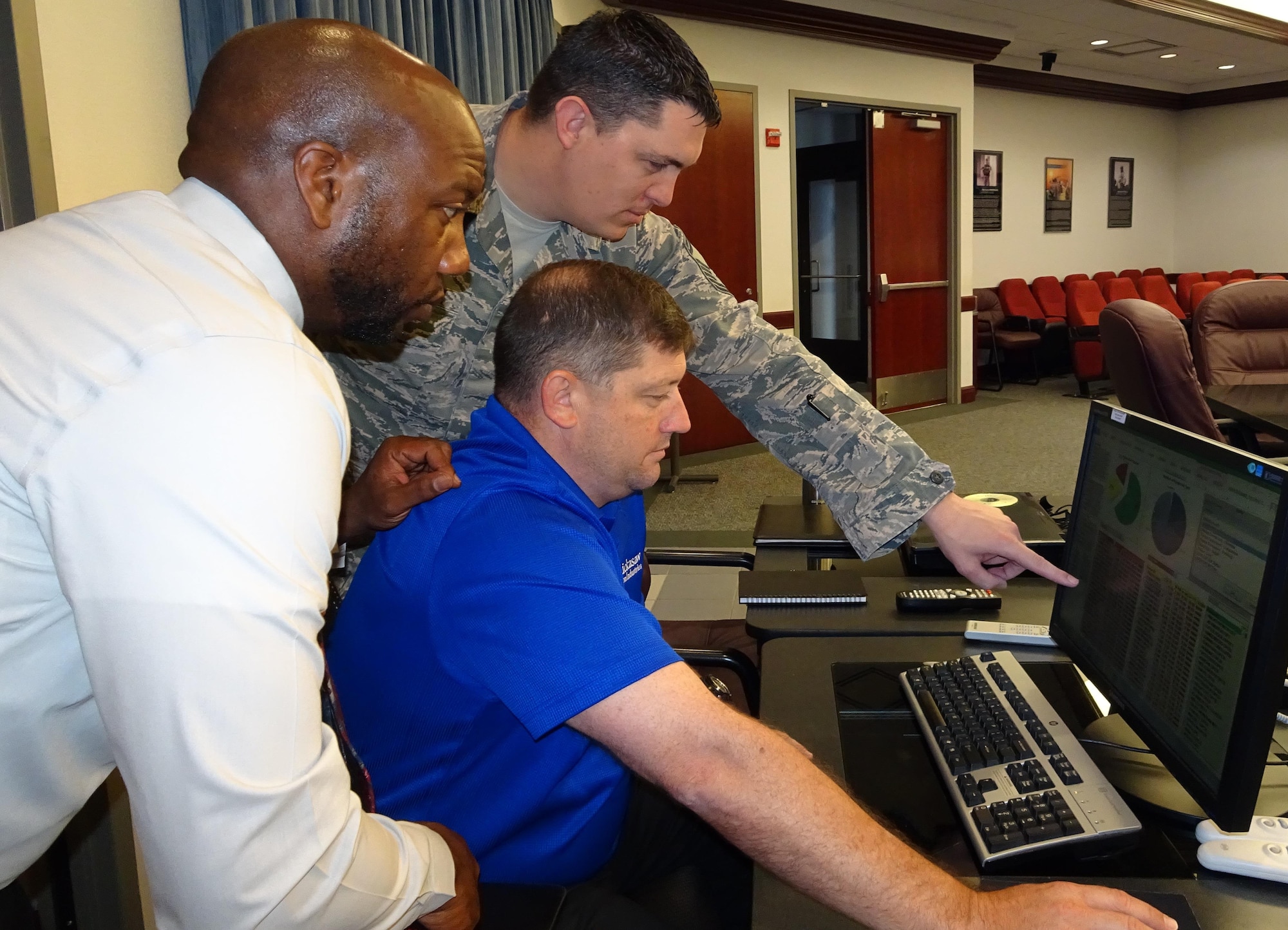 Senor Master Sgt. James Eselgroth (center), Combat Arms Program branch chief, Air Force Security Forces Center, points out trends to Eric Kennedy (left), Small Arms Ranges action officer, and Jason Abercrombie (seated), Combat Arms/Munitions action officer, as they review the newly created Small Arms Dashboard data program that provides a comprehensive, business-data model that ranks and prioritizes all Air Force firing ranges by vital statistics.