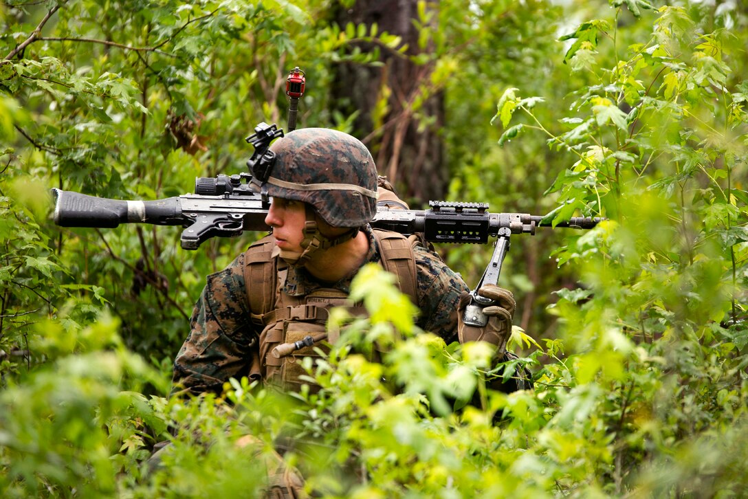 A Marine crouches to remain concealed during a combat readiness exercise at Camp Lejeune, N.C., June 21, 2017. Marines assigned to the 1st Battalion, 8th Marine Regiment, conducted an airfield seizure and movement to contact drills to maintain unit efficiency and prepare for future operations overseas. Marine Corps photo by Cpl. Luke Hoogendam