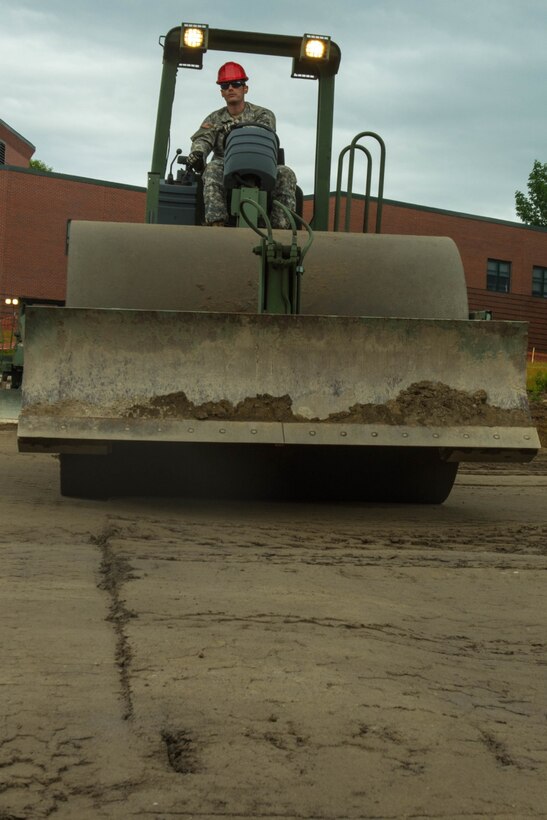 Maine Army National Guard Spc. Tyler Wheeler, a heavy construction equipment operator with the 262nd Engineer Company (Horizontal), operates a roller at the Raymond Elementary School in Raymond, Maine, June 24, 2017. The engineers turned a slope into a flat base for a multipurpose field as part of a training project that will benefit the school and surrounding community. Maine Army National Guard photo by Sgt. Sarah Myrick