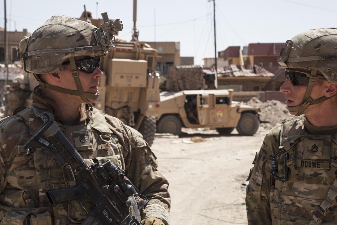 Soldiers talk outside an Iraqi forces headquarters in Mosul, Iraq, as they prepare to establish a new patrol base, June 19, 2017. Army photo by Cpl. Rachel Diehm