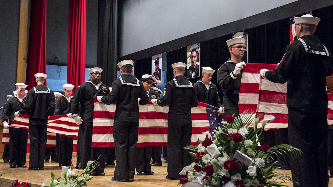 Sailors fold seven American flags during a memorial ceremony in Yokosuka, Japan, June 27, 2017, to honor the seven sailors assigned to the destroyer USS Fitzgerald who were killed in a collision at sea. Navy photo by Petty Officer 2nd Class Raymond D. Diaz III
