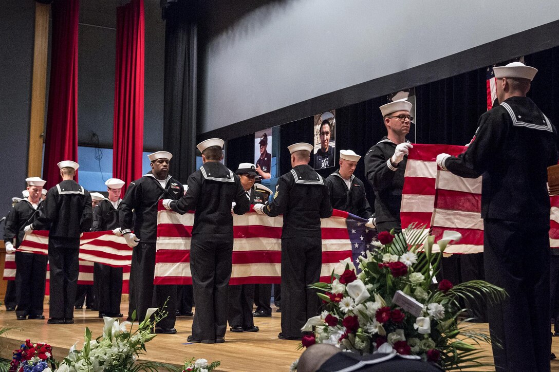 Sailors fold seven American flags during a memorial ceremony in Yokosuka, Japan, June 27, 2017, to honor the seven sailors assigned to the destroyer USS Fitzgerald who were killed in a collision at sea. Navy photo by Petty Officer 2nd Class Raymond D. Diaz III
