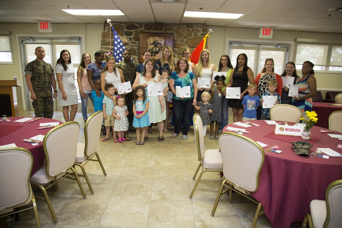 (Left) First Sergeant Neil Roselli, Marine Corps Logistics Base Barstow, Calif., and Col. Sekou Karega, commanding officer, MCLB Barstow, presented 17 military spouses with certificates of appreciation for their numerous volunteer activities throughout the year. The certificates were presented at a Military Spouse Appreciation Ceremony at the Maj. Gen. James L. Day Conference Center aboard base, June 19. The event was organized by Jesica Grow (second left), a Families Overcoming Under Stress (FOCUS) Resilience Trainer. FOCUS is an organization contracted by the Department of Defense to “… provide a range of resilience enhancing services to service members and their families” by helping military families develop coping mechanisms to deal with issues such as deployment of a spouse.