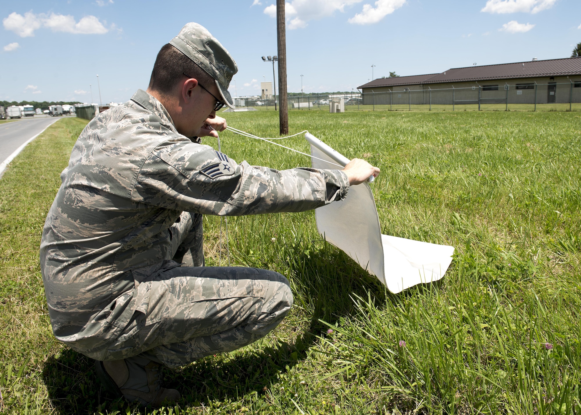 Senior Airman Moss Purcell, 436th Aerospace Medicine Squadron public health technician, checks a piece of white cloth for ticks June 9, 2017, at Dover Air Force Base, Del. Ticks that are caught are tested for diseases, including Lyme disease. (U.S. Air Force photo by Senior Airman Zachary Cacicia)