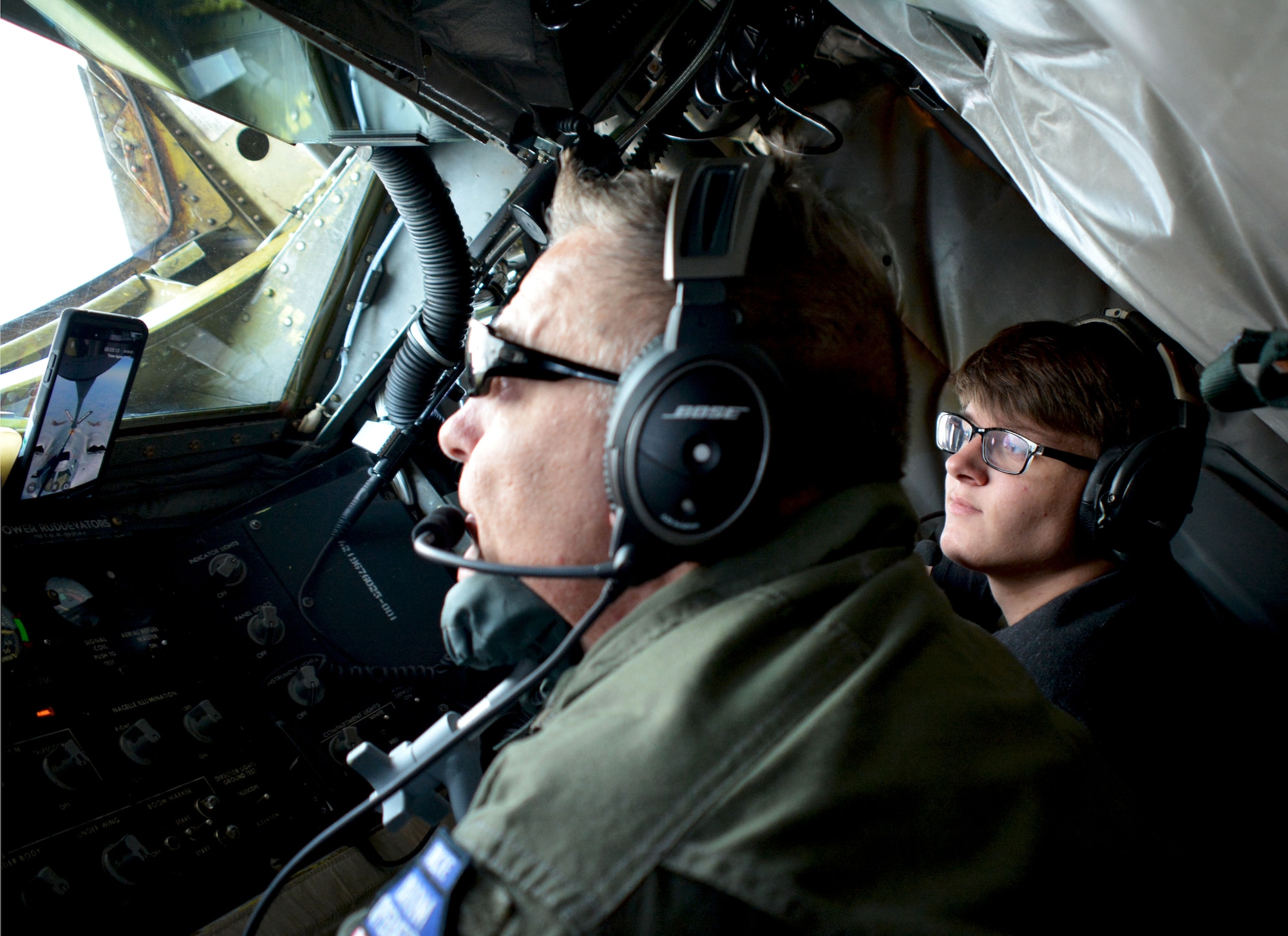 Senior Master Sgt. Darby Perrin, 465th Air Refueling Squadron boom operator, demonstrates refueling a B-2 Spirit bomber to his son Garrett Perrin, an Organization of Black Aerospace Professionals student, while flying in a 507th Air Refueling Wing KC-135 Stratotanker here June 20, 2017. Twenty-seven young OBAP aviators observed how the Air Force Reserve directly fuels the fight through preparation, training and striving for combat-readiness during their three-hour long orientation flight. (U.S. Air Force photo/Staff Sgt. Samantha Mathison)