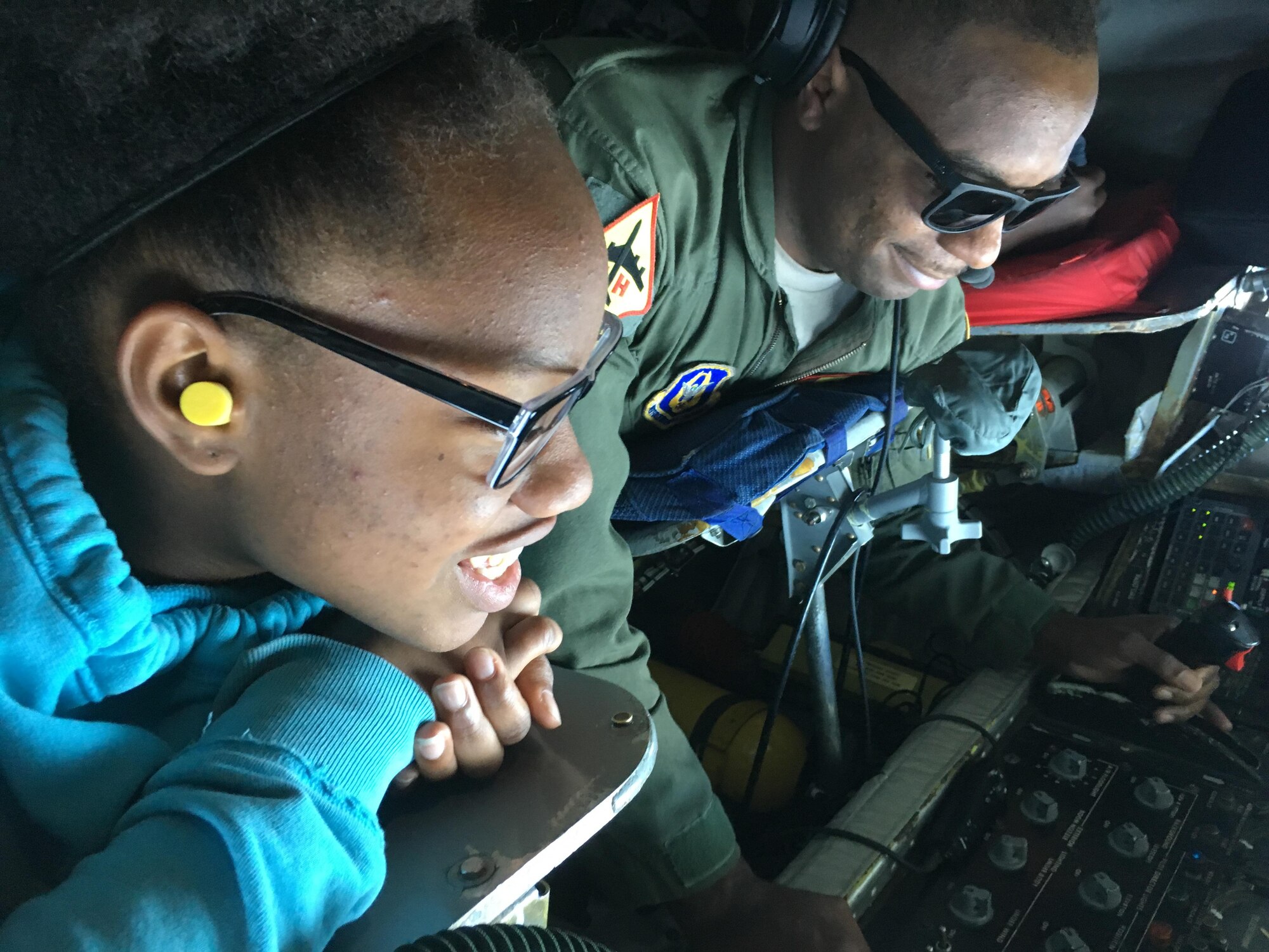 Tech. Sgt. Bobby Jackson, 465th Air Refueling Squadron boom operator, demonstrates refueling a B-2 Spirit bomber to Alexia Vence, an Organization of Black Aerospace Professionals student, while flying in a 507th Air Refueling Wing KC-135 Stratotanker here June 20, 2017. Twenty-seven young OBAP aviators observed how the Air Force Reserve directly fuels the fight through preparation, training and striving for combat-readiness during their three-hour long orientation flight. (U.S. Air Force photo/Staff Sgt. Samantha Mathison)