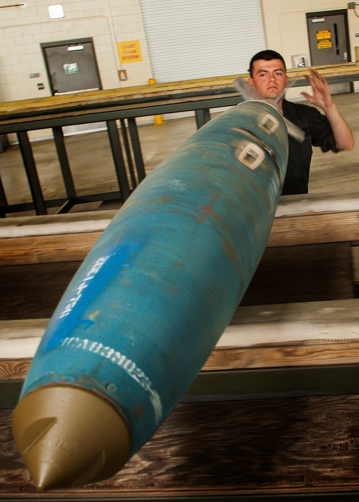 Senior Airman Brian Sanchez, 5th Aircraft Maintenance Squadron weapons load crew member, rolls an inert GBU-38 munition at Minot Air Force Base, N.D., June 19, 2017. The training muntions were loaded into an aircraft by the 5th AMXS Global Strike Challenge team during their bomb-loading competition. (U.S. Air Force photo/Senior Airman J.T. Armstrong)