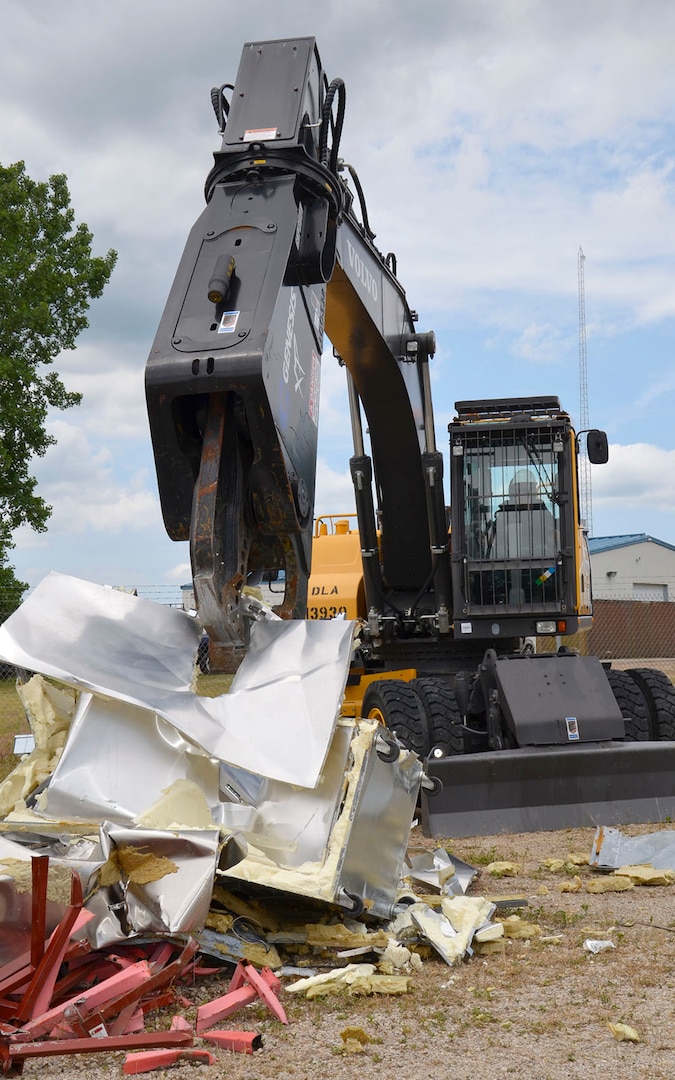 Navy Logistics Specialist 2nd Class Scott Pearson operates industrial shears to turn unusable property into scrap during OCORT 2017. 