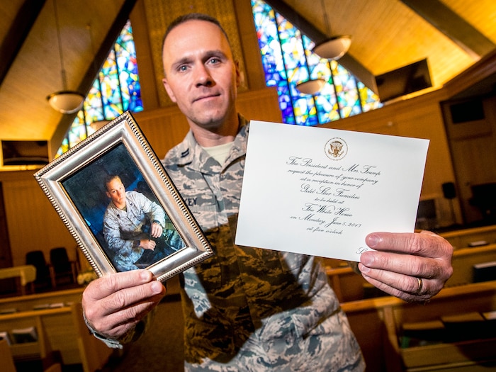 Chaplain (Capt.) Jeremy Caskey, 75th Air Base Wing, poses in the Hill Air Force Base Chapel June 22 with a photograph of his late brother, Marine Corps Sgt. Joseph Caskey, and an invitation to a reception in the White House. Chaplain Caskey visited Washington D.C. June 5 where he met President Donald Trump and First Lady Melania Trump during a reception for Gold Star families. (U.S. Air Force/Paul Holcomb)  