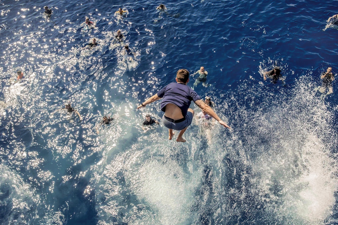 A sailor plunges from an aircraft elevator into the water during a swim call on the USS George H.W. Bush in the Mediterranean Sea, June 23, 2017. The Bush is conducting naval operations in the U.S. 6th Fleet area of operations. Navy photo by Petty Officer 1st Class Sean Hurt