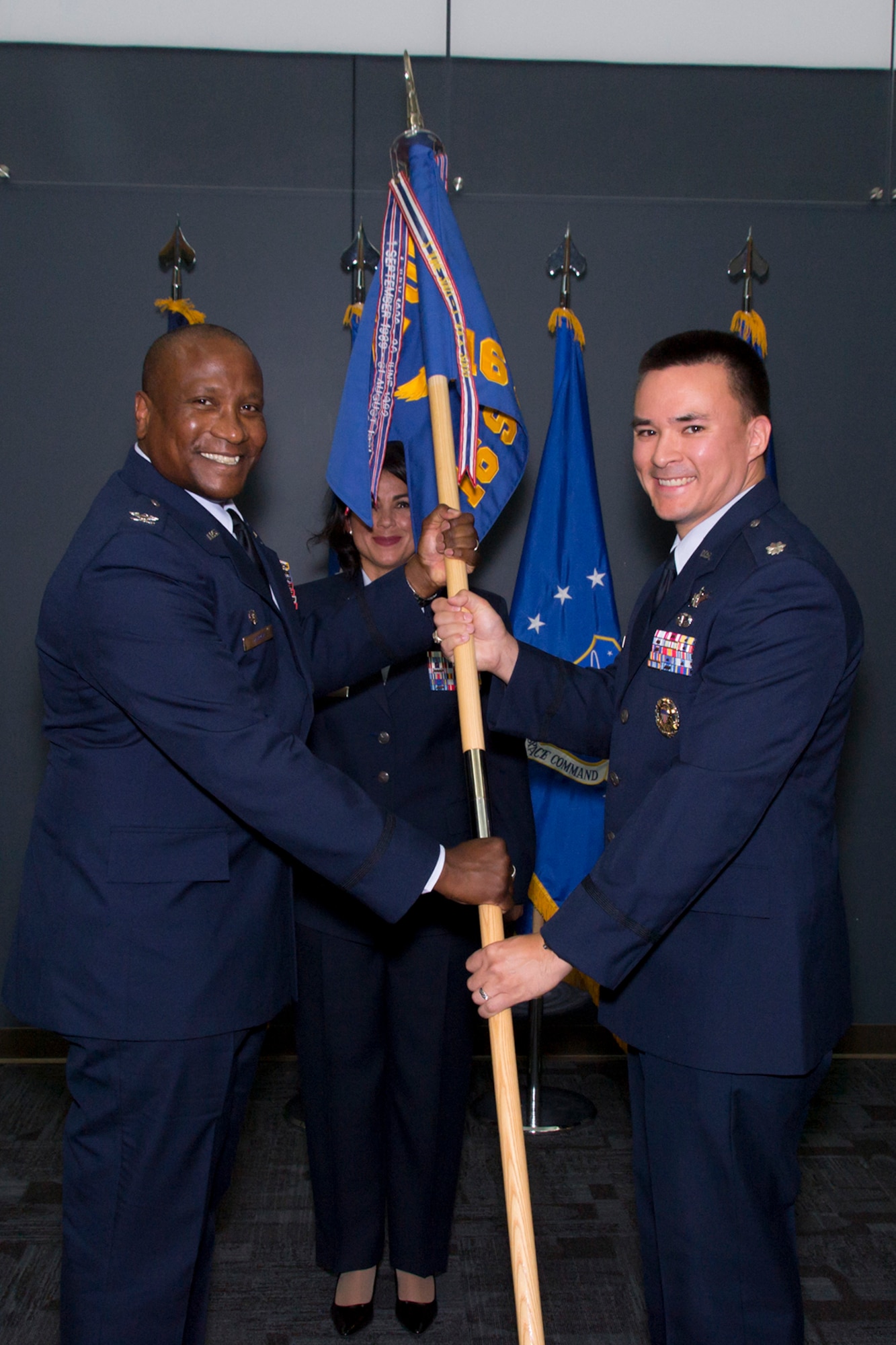 PETERSON AIR FORCE BASE, Colorado -- Col Devin Pepper, 21st Operations Group Commander, hands the 16th Space Control Squadron guidon to Lt Col Ernest Schmitt at a change of command ceremony, June 16, 2017, at Peterson Air Force Base, Colorado.  The 16th SPCS is Air Force Space Command’s only defensive space control unit and is responsible for operating defensive space control capabilities to rapidly achieve flexible and versatile space superiority.  The unit draws Total Force manpower support from its Reserve Associate Unit, the 380th Space Control Squadron.  (Courtesy Photo)