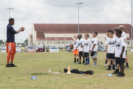 Terrance Williams, Dallas Cowboys wide receiver, coaches children during a youth football camp June 26, 2017, at Joint Base San Antonio-Randolph. JBSA-Randolph was one of the 11 military communities selected to host a 2017 ProCamps football event. (U.S. Air Force photo by Senior Airman Stormy Archer)