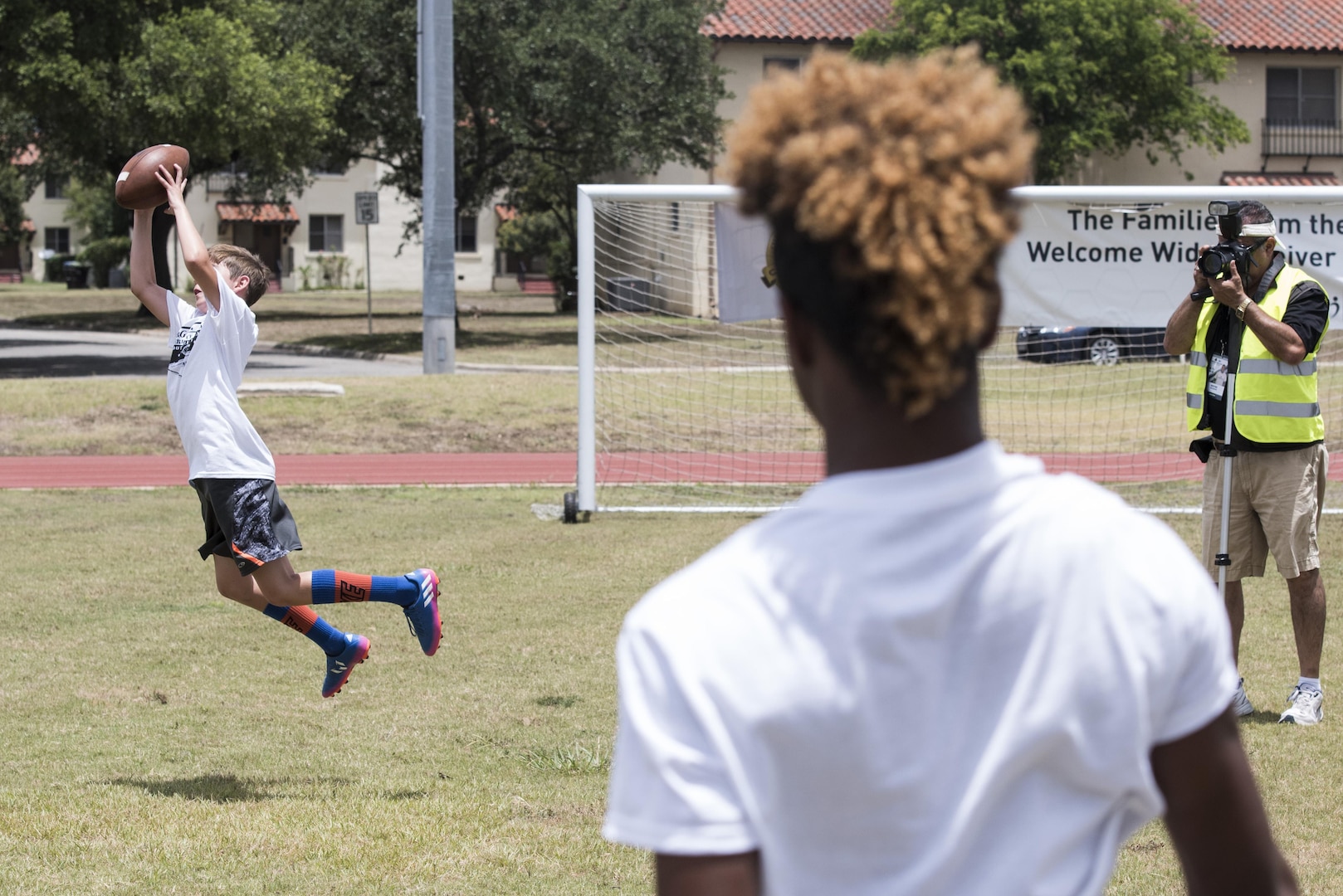 Terrance Williams, Dallas Cowboys wide receiver, coaches children during a  youth football camp June 26, 2017, at Joint Base San Antonio-Randolph.  JBSA-Randolph was one of the 11 military communities selected to host