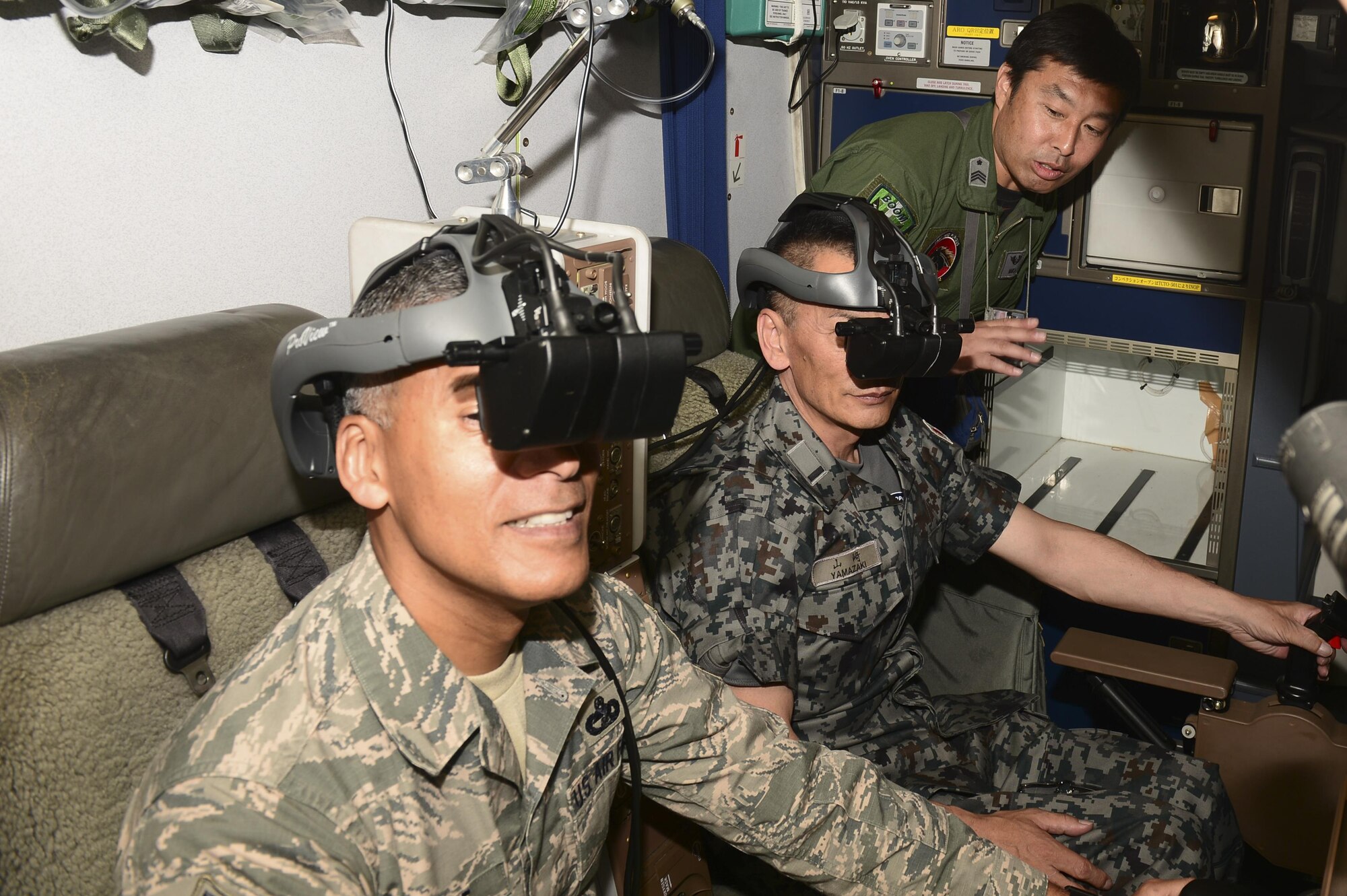 U.S. Air Force Chief Master Sgt. Terrence Greene, the fifth Air Force command chief, and Warrant Officer Katsumi Yamazaki, the senior enlisted advisor of the Japan Air Self Defense Force (JASDF), look through JASDF KC-767 goggles, June 23, 2017, at Eielson Air Force Base, Alaska. The JASDF KC-767 boom operators control the boom from a seat behind the cockpit. (U.S. Air Force photo by Airman 1st Class Isaac Johnson)