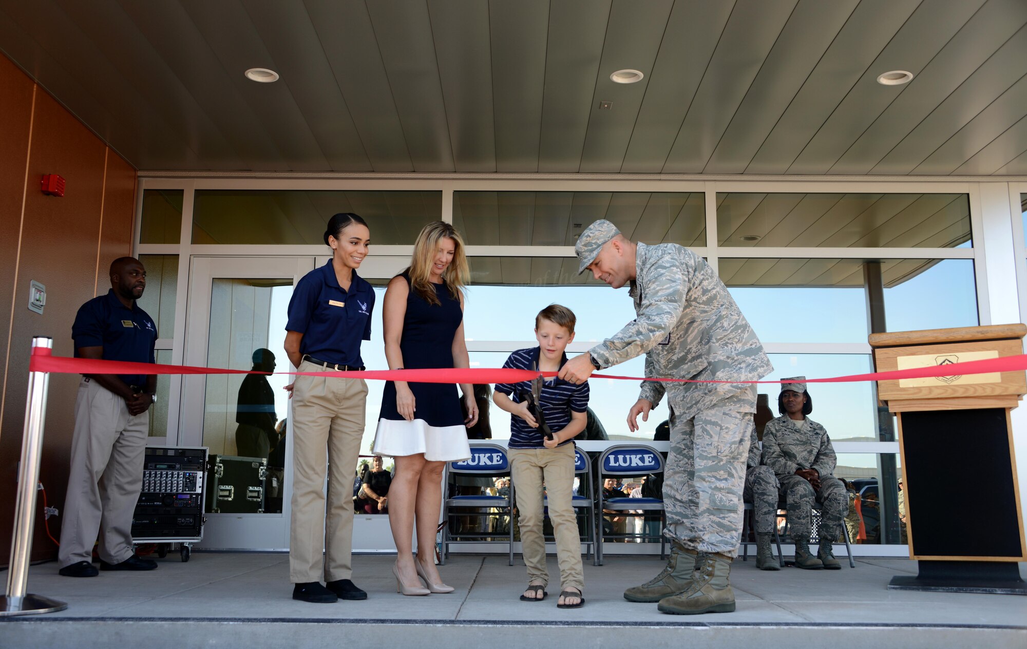 Brig. Gen. Brook Leonard, 56th Fighter Wing commander, assists 7-year-old Sean Luke, son of Frank Bryant Jr., in cutting the ribbon during Bryant Fitness Center’s Grand Opening Ceremony June 27, 2017, at Luke Air Force Base, Ariz. During the ceremony, the fitness center rededicated its name in honor of Frank Bryant Jr., an Airman who made the ultimate sacrifice for his country. (U.S. Air Force photo by Airman 1st Class Alexander Cook) 