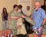 A 944th Aeromedical Staging Squadron Airman scheduled to deploy this summer, hugs Girl Scout Fiala Richard, 15,  June 23 after receiving a camo quilt made and given by Richard and her team of volunteers at Luke Air Force Base, Ariz. (U.S. Air Force photo by Tech. Sgt. Louis Vega Jr.)