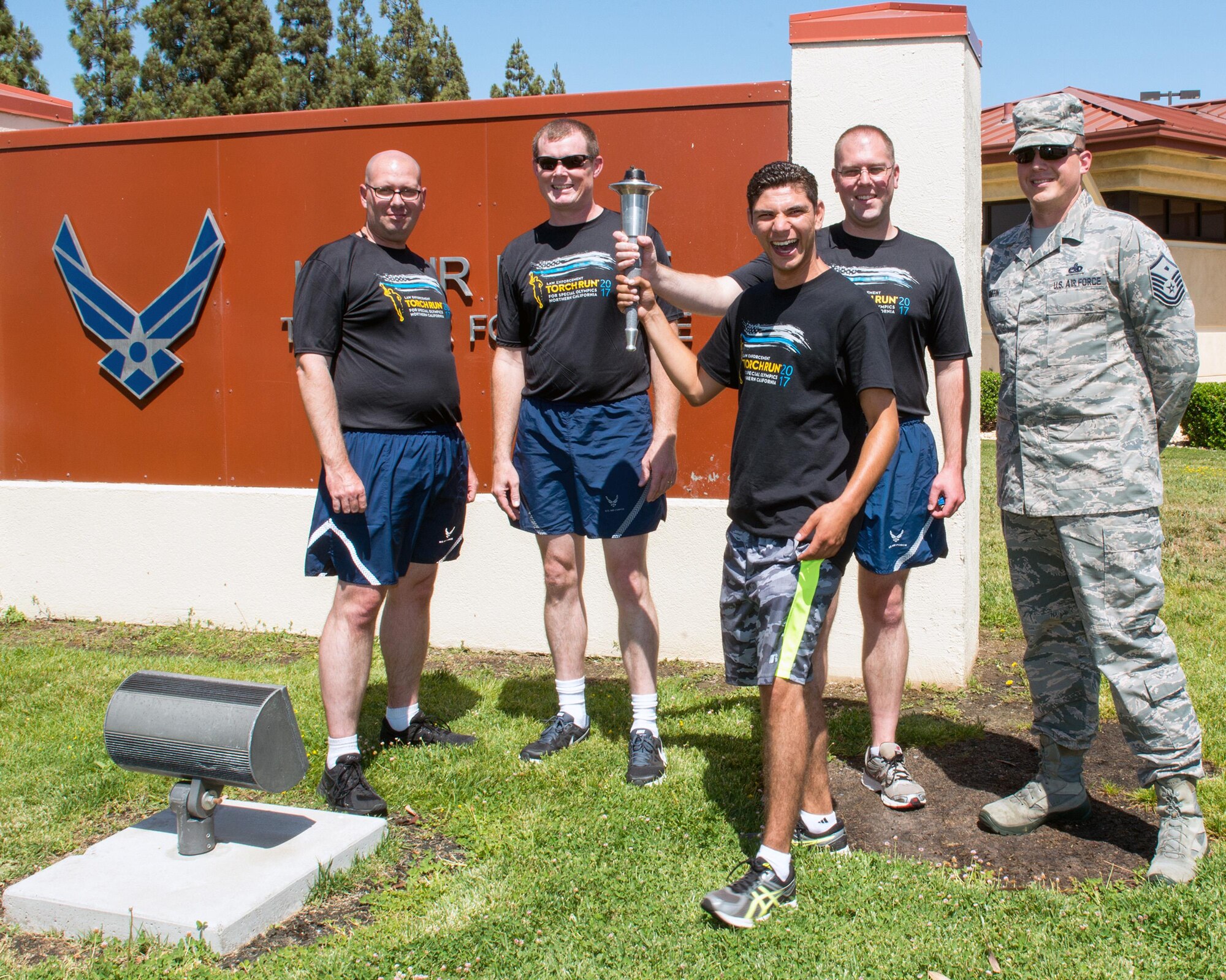 Members of the 60th Security Forces Squadron, Travis Air Force Base, Calif., pose for a photo with Eric Silva, a track and field athlete competing in the Special Olympics, June 21, 2017. Silva ran with “The Flame of Hope” Special Olympics Torch and presented it to the security forces Airmen during a ceremony at Travis. (U.S. Air Force photo by Louis Briscese)
