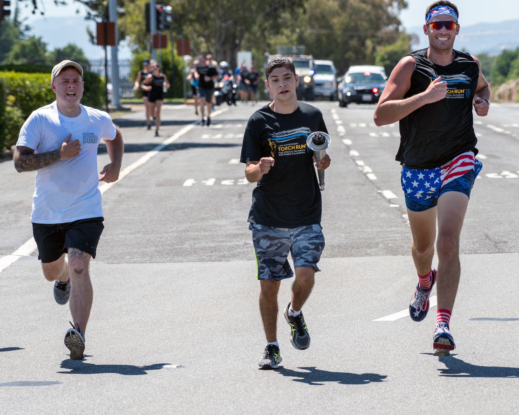 Eric Silva, a track and field athlete competing in the Special Olympics, runs with police officers from the Fairfield Police Department to deliver “The Flame of Hope” Special Olympics Torch to Travis Air Force Base, Calif., June 21, 2017. The torch run brings local law enforcement together from Solano County to show their support for the Special Olympics. (U.S. Air Force photo by Louis Briscese)