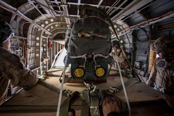 Marine parachute riggers with 1st Marine Logistics Group and a crew chief with Marine Operational Test and Evaluation Squadron-22 (VMX-22) prepare to deploy a palletized load from above 10,000 feet during the Joint Precision Airdrop System testing Aug. 1, at the U.S. Army Yuma Proving Ground. The JPADS systems use GPS, a modular autonomous guidance unit, or MAGU, a parachute and electric motors to guide cargo within 150 meters of their target points. Marine Corps Systems Command fielded the last of 162 JPADS to the fleet in April, turning the page from acquisition to sustainment of the system for the Corps. (U.S. Marine Corps photo by Cpl. Reba James)