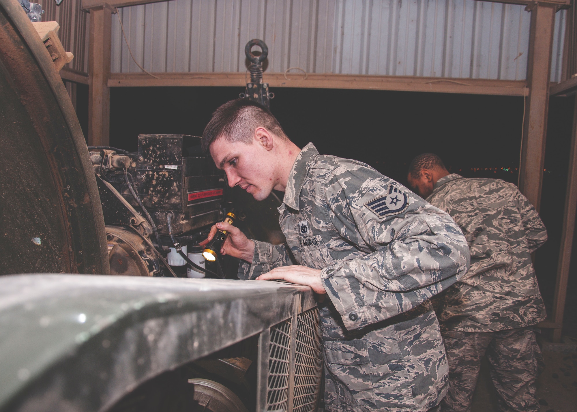 Staff Sgt. Michael Weixlmann, a power production specialist assigned to the 386th Expeditionary Civil Engineer Squadron, (left) conducts and inspection on a mobile aircraft arresting system at an undisclosed location in southwest Asia, June 24, 2017. A visual inspection is performed on these units daily. (U.S. Air Force Photo/Master Sgt. Eric M. Sharman)
