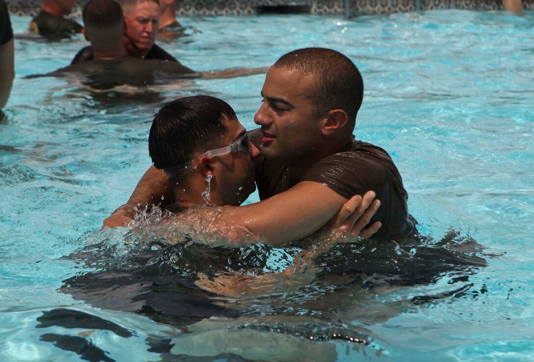 U.S. Marine Sgt. Jorge P. Calle, left, an infantry tactics instructor with the Mobile Training Team, Command Element, Special Purpose Marine Air-Ground Task Force - Southern Command, performs a search and rescue technique on Sgt. Francis A. Nova, an infantry tactics instructor with the MTT, during a water survival course at Soto Cano Air Base, Honduras, June 13, 2017. The course consisted of basic water survival skills as well as search and rescue techniques. (U.S. Marine Corps Photo by Lance Cpl. Serine Farahi)