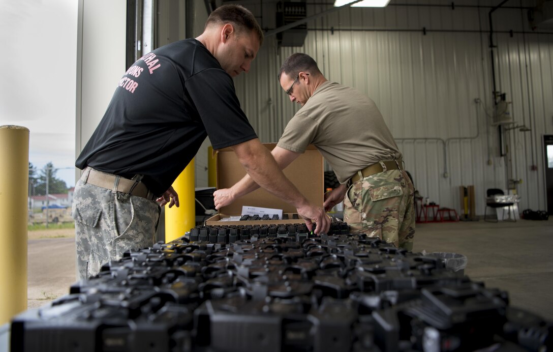 Staff Sgt. John Karambelas with the 327th Military Police Battalion and Staff Sgt. Michael L. Dye, with the 447th MP Company, both U.S. Army Reserve military police and interservice, non-leathal weapons insructors, set out Tasers and live cartridges for Taser certification during Guardian Justice at Fort McCoy, Wisconsin, June 22. Guardian Justice is a functional exercise, broken down into two-week cycles, centered on squad and team-level training with a focus on internment, resettlement, detainee operations and combat support. During each two-week cycle, Soldiers train on internment operations, weapons qualification, biometrics, reflexive fire, Military Operations on Urbanized Terrain (MOUT), non-lethal Tasers, MP battle drills and situational training exercises. (U.S. Army Reserve photo by Sgt. Audrey Hayes)