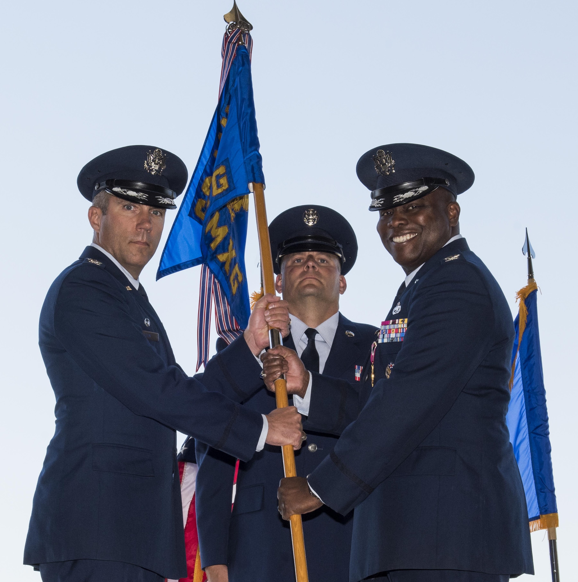 U.S. Air Force Col. John Klein, commander, 60th Air Mobility Wing, Travis AFB, Calif., receives the 60th Maintenance Group guidon from Col. Earl Scott, outgoing 60th MXG commander, during a Change of Command Ceremony where Scott relinquished command to Col. David A. Hammerschmidt, June 23, 2017. The 60th Maintenance Group has 2,200+ active, civilian, and reserve personnel supporting organizational and field-level maintenance for 18 C-5M Super Galaxy, 13 C-17 Globemaster, and 27 KC-10 Extender aircraft at Air Mobility Command's largest wing. U.S. Air Force Col. Earl S. Scott relinquished command to Col. David A. Hammerschmidt during a ceremony rooted in military history dating back to the 18th Century where the command flag is passed to the individual assuming command in the presence of the entire unit. (U.S. Air Force photo/ Heide Couch) 