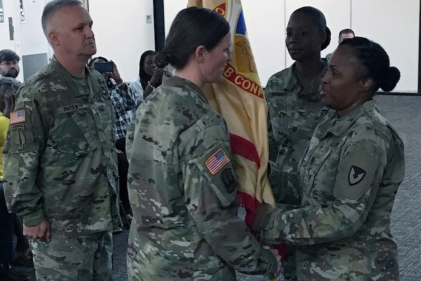 Command Sgt. Maj. Andrea Dailey (right), 408th Contracting Support Brigade senior enlisted advisor, passes the 408th CSB’s colors to Col. Michelle Sanner (left), 408th CSB outgoing commander, during a change of command ceremony at Shaw Air Force Base, S.C. Thursday. Sanner relinquished command of the 408th CSB to Col. Kim Thomas (second to left), 408th incoming CSB commander.