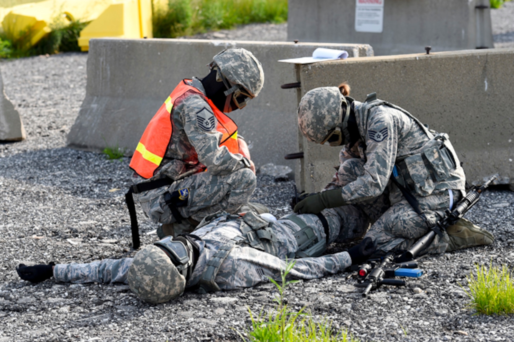 Master Sgt. Michael Rush, 434th Security Forces Squadron craftsman, advises Staff Sgt. Natalie Borrini, 434th SFS fire team member, as she applies a tourniquet to Senior Airman Charles Reed, 434th SFS fire team member during dynamic tactical training, June 4 at Grissom Air Reserve Base, Ind. This training allows SFS members to improve readiness for real life tactical situations. (U.S. Air Force photo/Senior Airman Cali Wetli)
