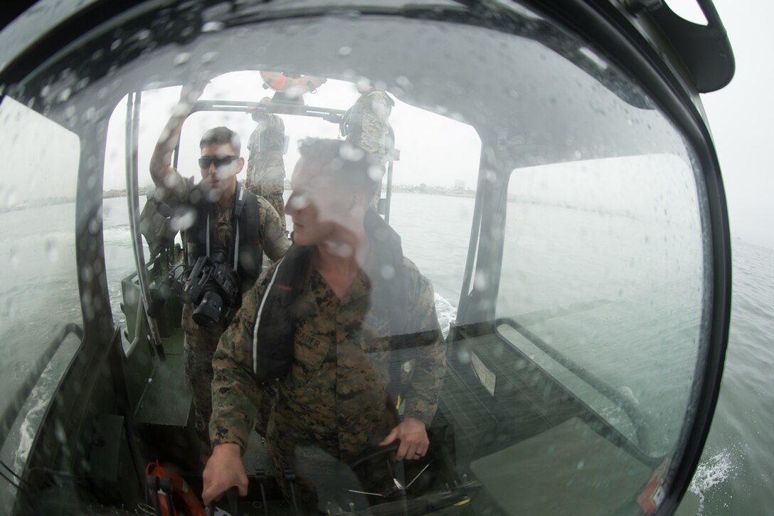U.S. Marine Cpl. Braxton Shrader, a combat engineer with Bridge Company, 7th Engineer Support Battalion, 1st Marine Logistics Group observes his surroundings while afloat the Bridge Erection Boat (BEB) during a boat licensing course on the water along the coast of Camp Pendleton, Calif., June 21, 2017. The BEB deploys improved ribbon bridges, which are long two-way platforms used to transport heavy equipment, such as tanks, over bodies of water. (U.S. Marine Corps photo by Lance Cpl. Timothy Shoemaker)